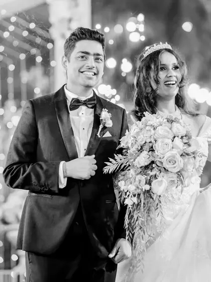 A closer shot of the couple during their grand entrance. This black and white candid highlights their happy expressions amidst the celebration.