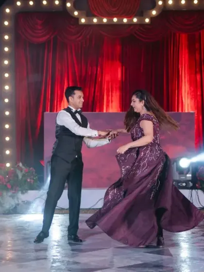 The stage is set for a show-stopping performance. With dramatic lighting and a classic red curtain backdrop, this Broadway-themed Sangeet stage was the perfect setting for the couple's first dance.