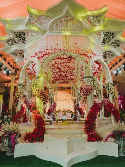 This grand, multi-tiered mandap was a masterpiece of design. The intricate white structure, adorned with arches of red florals, created a regal and opulent atmosphere for a truly magnificent wedding ceremony.