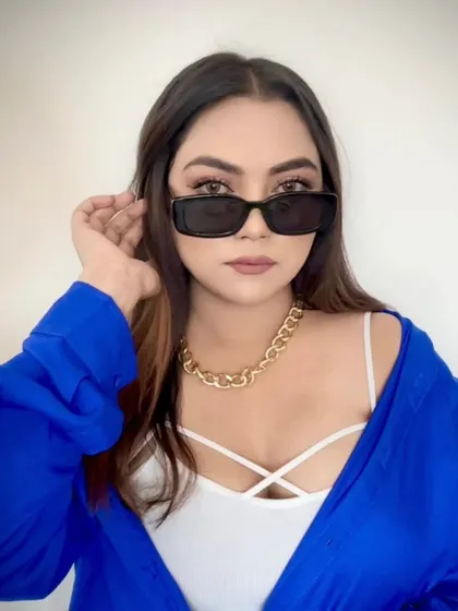 A stylish look with sunglasses and an open blue shirt.