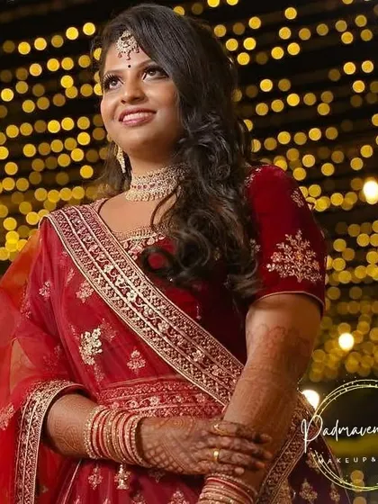 The bride against a backdrop of fairy lights. Her glowing skin and shimmering makeup catch the light beautifully, making her the center of attention.