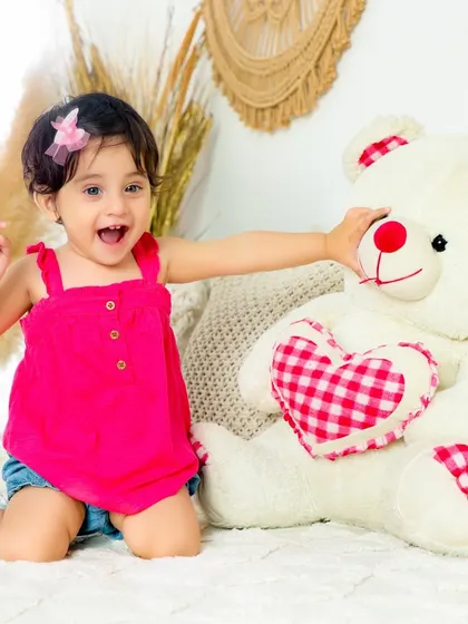 A playful moment with a giant teddy bear. This photo captures the fun and energy of a child's interaction with her favorite toy.