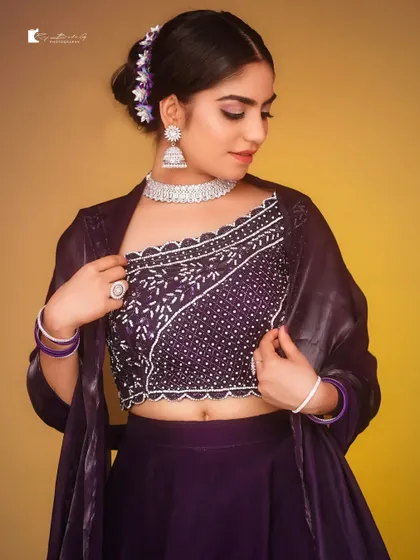 A duplicate image of the model in the purple lehenga.