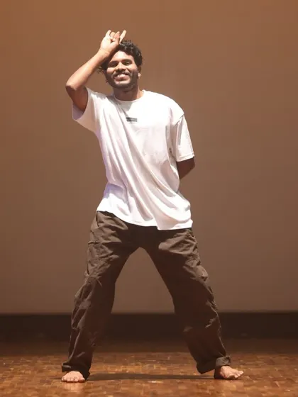 An instructor demonstrates a relaxed yet sharp move from a hip-hop routine. Our classes are designed to be high-energy and stress-free.
