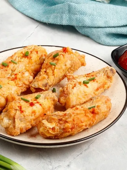 Our crispy Fried Chicken Wings, garnished with a sprinkle of chilli flakes and chives for a little extra flavour.