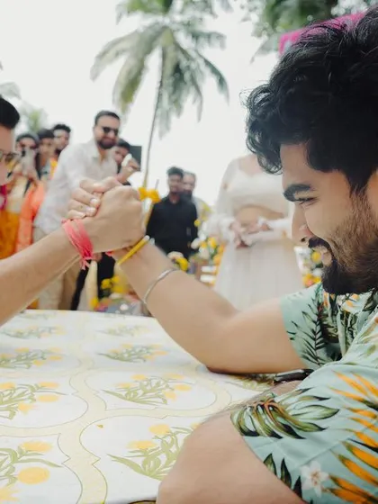 A friendly arm-wrestling match between the bride and groom's sides brings a dose of fun and competition to the Haldi festivities.
