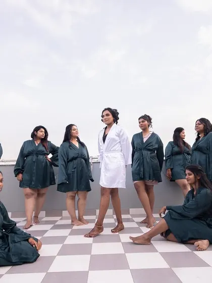 The bride and her squad posing on a rooftop, a modern and fun take on the classic bridesmaid photoshoot.