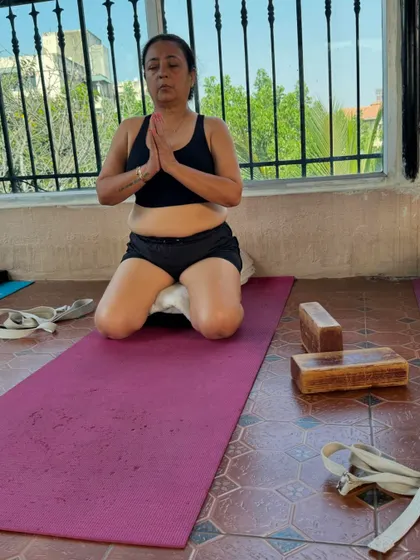 A student finds stillness in Virasana (Hero Pose) on a cushion. This posture is excellent for meditation and improves posture and digestion.