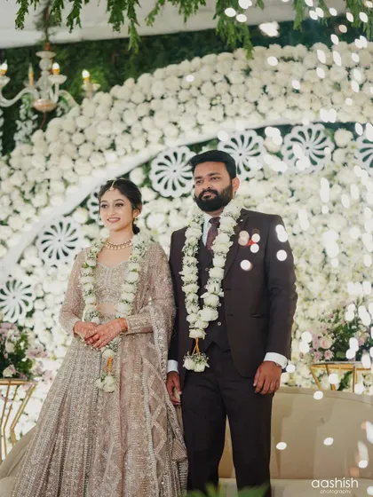 The couple on their reception stage. The bride's makeup is designed to be impactful and photogenic, even from a distance.