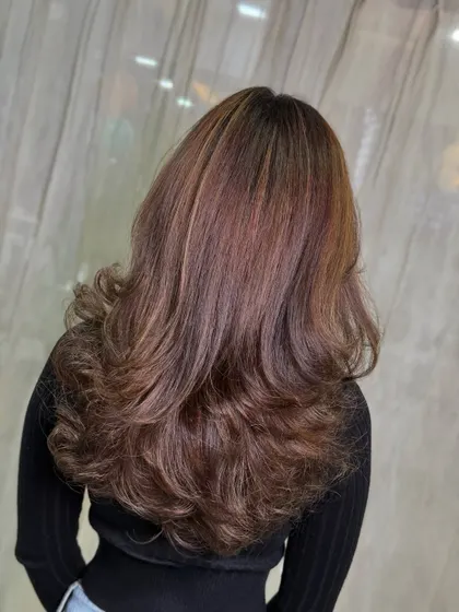 This transformation from frizzy and undefined hair to a smooth, layered style shows the power of a good cut and color. The dessert-inspired tones add warmth and richness.
