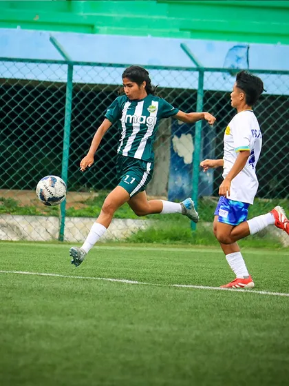 A player makes a powerful run with the ball, showcasing her speed and determination during a rainy Matchday 5 fixture.