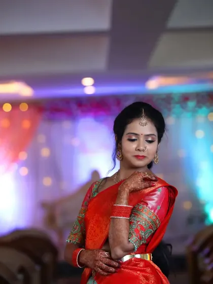A classic pose from Priya's engagement. The bold red saree and intricate blouse were balanced with a defined eye and a warm, glowing complexion.