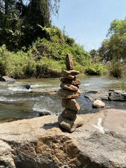 A cairn of balanced stones by a river. This is another form of meditative art, finding stillness and balance in nature.