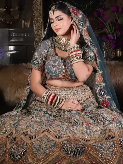 A beautiful candid-style shot of the bride, highlighting the soft, glowing makeup and the intricate details of her jewelry and outfit.