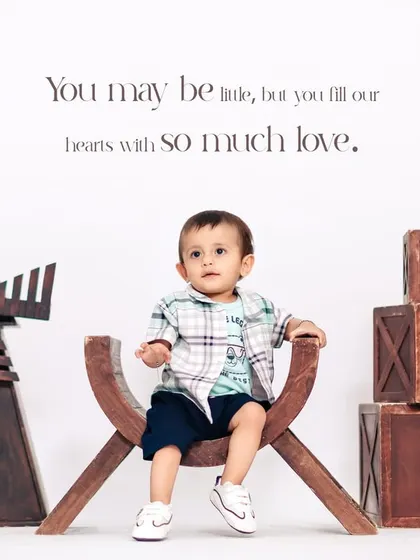 A charming studio portrait for a first birthday, featuring our rustic props like the wooden windmill and "ONE" blocks. We create a complete, stylized scene for your child.
