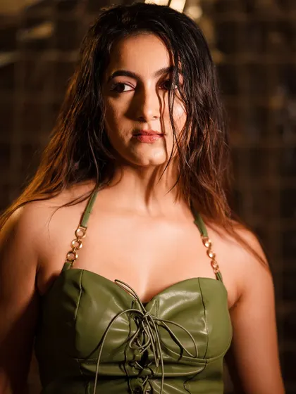 A close-up from the same series, focusing on the intense expression. The lighting highlights the texture of the leather top and creates a dramatic mood.