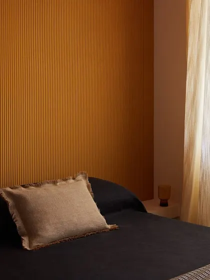 The 'Colonne' wallcovering from Élitis, featuring endless vertical stripes that evoke timeless depth. The ribbed lines offer a tactile and visual journey, redefining serenity for modern interiors.
