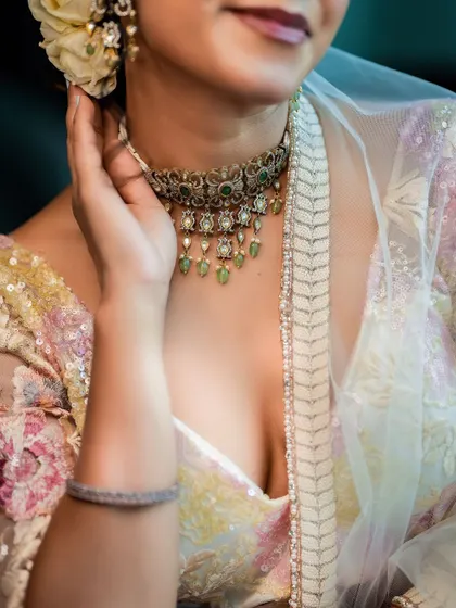 A detailed shot focusing on the texture of the blouse, the sheer dupatta, and the elegant choker necklace.
