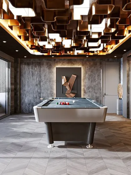 Another view of the game room, highlighting the concrete-finish wall and modern art piece that add an edgy, industrial touch to the sophisticated design.