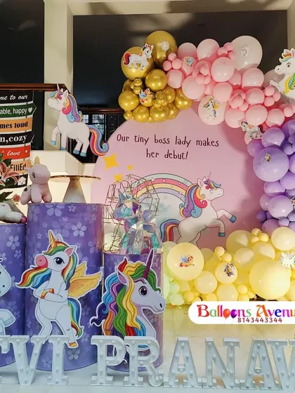 A complete unicorn-themed birthday party setup. This magical design includes multiple unicorn cutouts, a rainbow backdrop, pastel and gold balloons, and personalized light-up letters for the birthday girl.