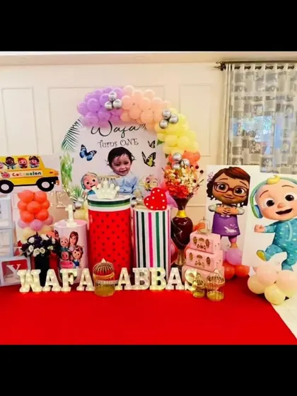 We created this fun Cocomelon world for Wafa Abbas's first birthday, featuring the iconic yellow school bus and a rainbow of balloons.