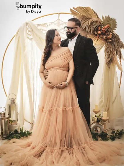 A beautiful portrait of a couple in our boho themed studio setup. The soft fabrics and earthy tones create a serene and romantic atmosphere for a maternity photoshoot.