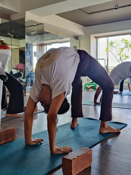 In our TTC, we emphasize the importance of props to build strength and alignment. Students here are practicing Chakrasana (Wheel Pose) with the support of blocks, learning how to make advanced backbends more accessible.