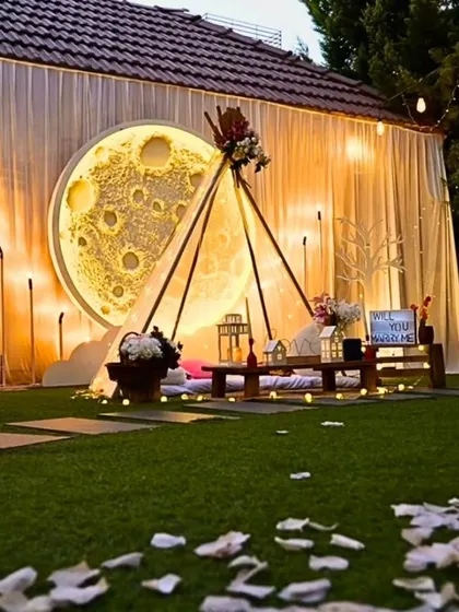 I design unique and dreamy settings, like this "Love you to the moon and back" theme. The large, illuminated moon backdrop, cozy teepee, and warm lighting create a magical atmosphere for a romantic evening.