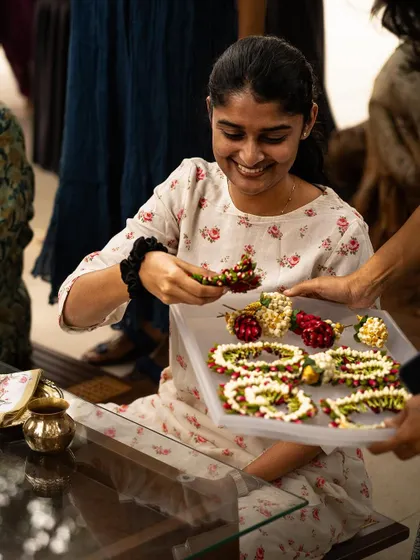 A participant at our workshop, smiling as she works with handcrafted floral jewelry. It was a joy to see so many creative minds exploring the art of traditional styling.