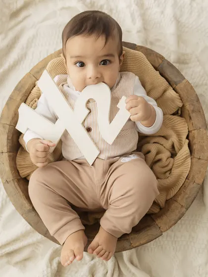 A cheeky little taste. This six-month-old is exploring his half-birthday sign, a fun and authentic moment from his milestone session.