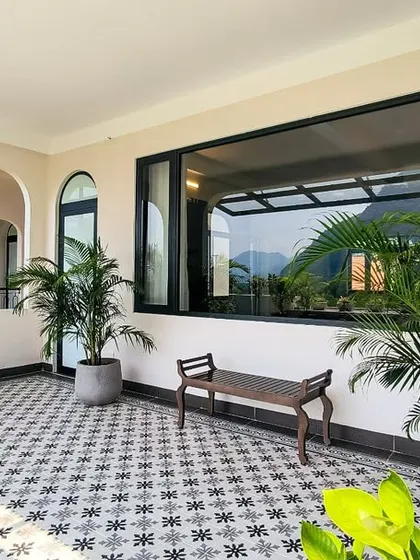 This beautifully designed patio blends modern aesthetics with lush greenery, featuring bold patterned tiles and a seamless indoor-outdoor connection.