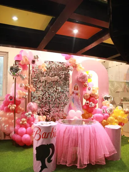 The main stage for a Barbie party, complete with a pink tulle table skirt, a sequin backdrop, and character silhouettes. It's the perfect setup for a fashion-forward celebration.