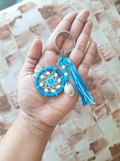 A dark blue version of our shell-adorned dreamcatcher keychain. The contrast between the deep blue and the white shell makes this a striking accessory.
