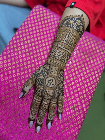 A full-coverage design with a central monogram. The pattern is a mix of traditional motifs and geometric grids, creating a very rich texture.