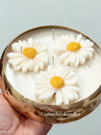Holding the 6-inch daisy urli candle to show its size. It's a substantial, statement decor piece.