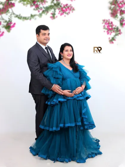 A classic couple's portrait. The parents-to-be stand together in a formal pose, with the mom-to-be wearing a beautiful tiered blue gown. This shot is perfect for a timeless memory.