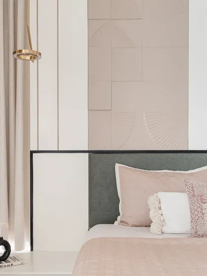 Soft pastel pinks and a textured fan-patterned wall create a gentle and modern bedroom. The design focuses on subtle textures and a calm color scheme to craft a restful and stylish space.