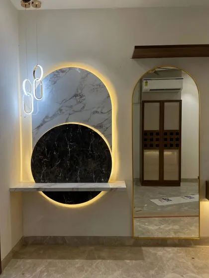 A still shot of the stunning, custom-built wall feature. The combination of black and white marble, backlighting, and a large mirror is truly eye-catching.