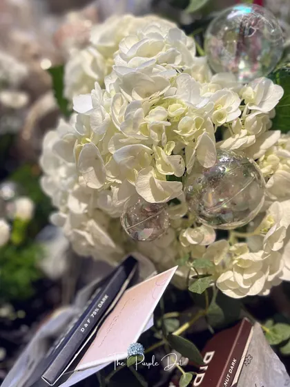 A close-up of the lush white hydrangeas and elegant details within the founder's gift.