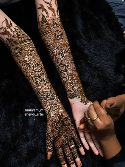 A shot of me applying a full-arm bridal mehendi, ensuring every detail is perfect.
