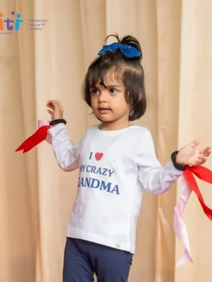 A little girl proudly wears a shirt that says "I love my crazy grandma" for her performance. The day is a heartfelt tribute to the special role of grandparents.