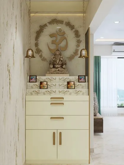 A compact and elegant mandir design, perfect for an apartment. It features a carved "Om" symbol, hanging bells, and a chest of drawers for storing prayer essentials.