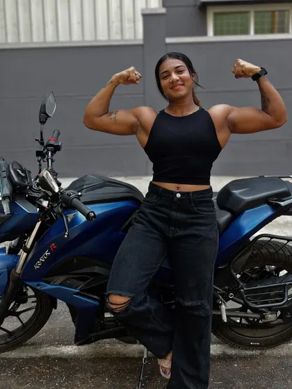 Posing with my bike. A double bicep flex next to my ride, combining two of my passions: fitness and bikes.