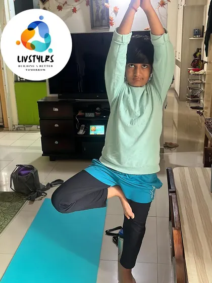 A young client stands tall in Vrikshasana (Tree Pose), a classic balancing posture that improves focus and stability.