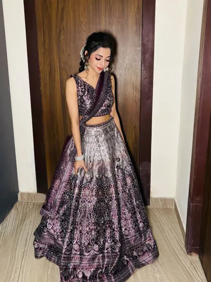 A full-length shot of the client in her beautiful purple lehenga.