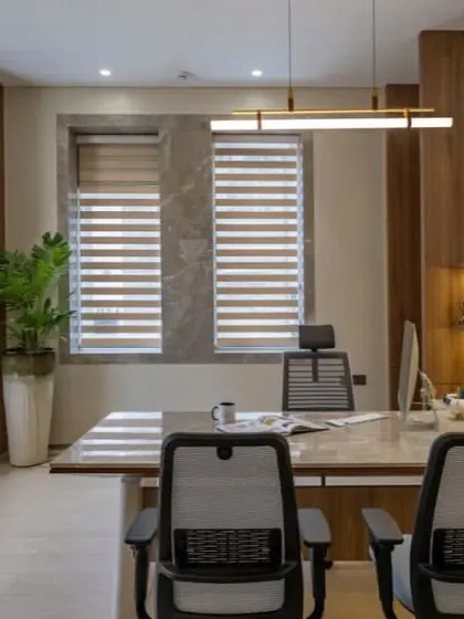Natural light is a key element in this executive office. Large windows with adjustable blinds allow for control over the lighting, creating a bright and energizing workspace.
