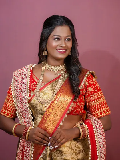 A full portrait of the model, looking radiant and confident in a traditional saree.