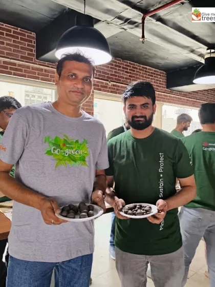 Two employees from Amdocs/Nxtra showing their handmade seed balls. It's a simple activity with a potentially huge environmental impact.