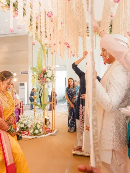 The bride and groom are separated by a cloth before they see each other for the first time at the mandap, a key ritual in Marathi weddings. The anticipation in this moment is palpable.