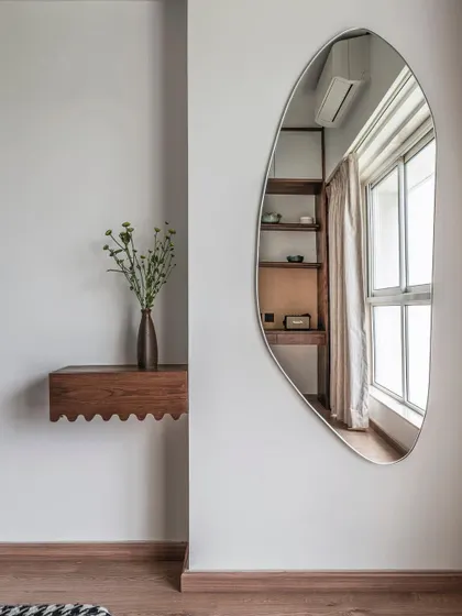 A detail from Apartment 1501, showing a custom floating shelf and an organic-shaped mirror. These small, thoughtful details add personality and a sense of curated design to the space.